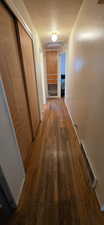 Hallway with dark wood-style floors and a textured ceiling