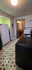 Kitchen with freestanding refrigerator, washer / clothes dryer, and light floors
