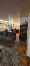 Living area with dark wood-type flooring and a textured ceiling
