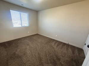 Empty room featuring carpet floors and baseboards