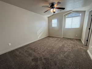 Unfurnished room featuring carpet, a textured ceiling, and ceiling fan