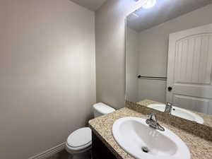 Half bathroom featuring toilet and vanity