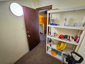 Hall featuring dark colored carpet