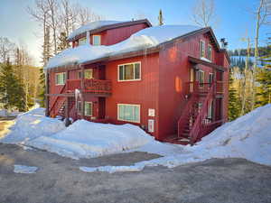 Snow covered property featuring stairway