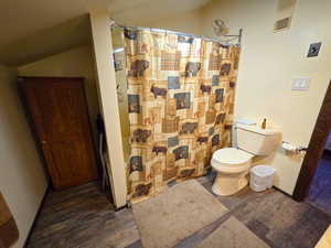 Full bathroom featuring dark wood-style floors and toilet