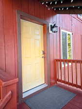 Doorway to property with a deck and board and batten siding