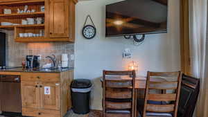 Kitchen with backsplash, brown cabinetry, dark stone countertops, and open shelves