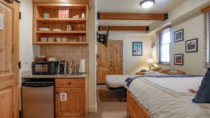 Bedroom featuring a sink and beamed ceiling