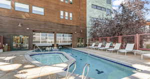 Indoor pool with a hot tub and a patio