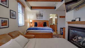 Bedroom featuring a tiled fireplace and ensuite bathroom