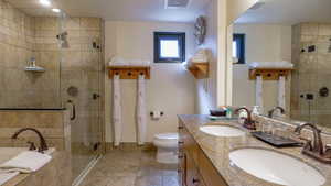 Full bathroom with double vanity, a bath, and a shower stall