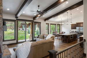 Living room featuring ceiling fan, dark wood finished floors, recessed lighting, a chandelier, and beamed ceiling