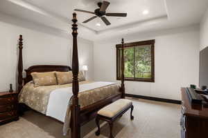 Bedroom featuring a raised ceiling, light carpet, recessed lighting, and ceiling fan
