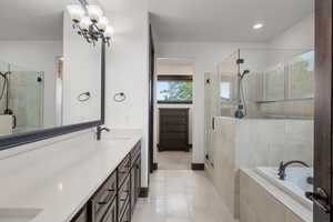 Bathroom with double vanity, a shower stall, a bath, and light tile patterned flooring