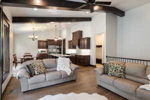 Living area with beam ceiling, a chandelier, a ceiling fan, wood finished floors, and recessed lighting
