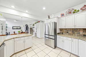 Kitchen with stainless steel appliances, white cabinets, pendant lighting, and recessed lighting