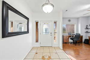 Entryway featuring light tile patterned floors and ceiling fan
