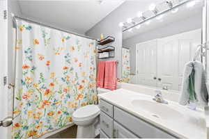 Bathroom featuring a shower with shower curtain, vanity, and dark tile patterned floors