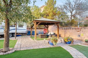 Fenced backyard featuring a gazebo, an outdoor living space, and a patio