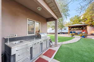 View of patio with a gazebo, exterior kitchen, and outdoor lounge area