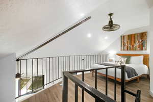 Bedroom with light wood-style floors and lofted ceiling