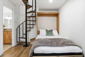 Bedroom with light wood-type flooring and ensuite bathroom