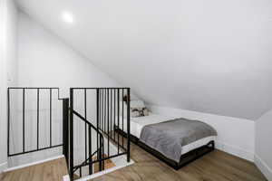 Bedroom featuring vaulted ceiling and wood finished floors