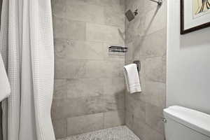Bathroom featuring a shower stall and a textured wall