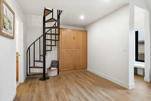 Foyer entrance with stairway and light wood finished floors