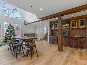 Dining room with light wood-type flooring, stairs, recessed lighting, and a decorative wall