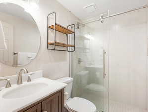 Full bath featuring a shower stall and vanity