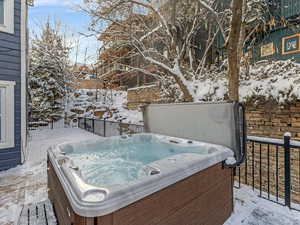 Snow covered deck with a hot tub