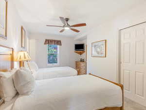 Bedroom with light colored carpet and a ceiling fan