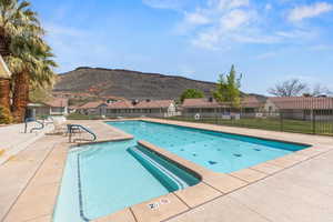 Community pool featuring a patio area, a residential view, and a mountain view