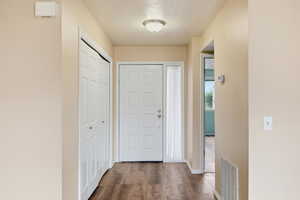 Entryway with dark wood finished floors and a textured ceiling