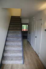 Stairway featuring wood finished floors and baseboards