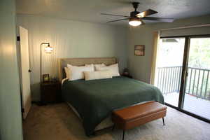 Carpeted bedroom with access to outside, ceiling fan, and a textured ceiling