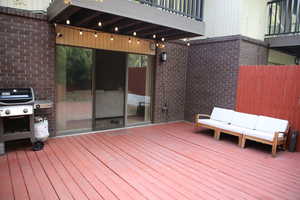 Wooden deck featuring outdoor lounge area and area for grilling