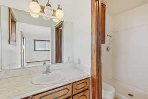 Full bath featuring a stall shower and vanity