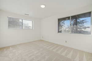 Empty room featuring light carpet and baseboards