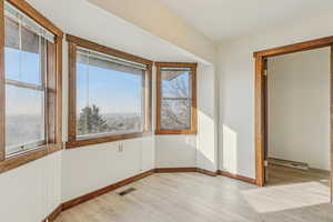 Empty room with healthy amount of natural light and light wood-type flooring