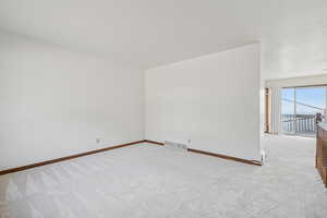 Carpeted spare room with baseboards