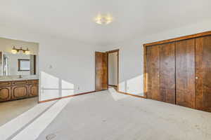 Unfurnished bedroom with light carpet and baseboards