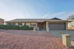 Single story home featuring driveway, brick siding, a garage, and a shingled roof