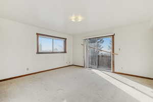 Carpeted empty room featuring baseboards