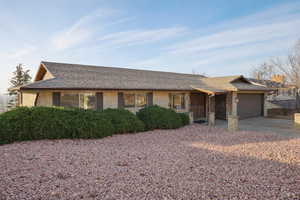 Single story home featuring brick siding, concrete driveway, a garage, and a shingled roof