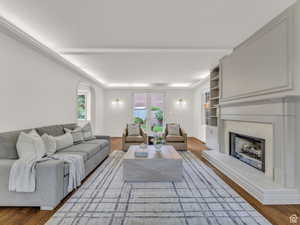 Living area featuring a premium fireplace, arched walkways, and wood finished floors