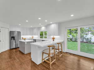 Kitchen with a breakfast bar, a center island, a peninsula, appliances with stainless steel finishes, and recessed lighting