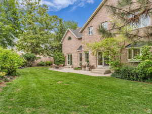 Back of house featuring a patio and brick siding