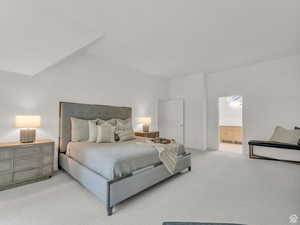 Bedroom featuring carpet flooring, ensuite bath, and lofted ceiling
